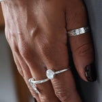 A close-up image of a person's hand showcasing a Starry Night ring on their finger, with the ring's embossed stars visible. The background suggests a home environment.