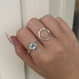 Hand wearing two silver rings with a light-colored background